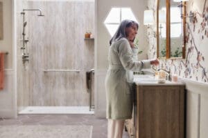 older woman standing in bathroom with her accessible shower behind her